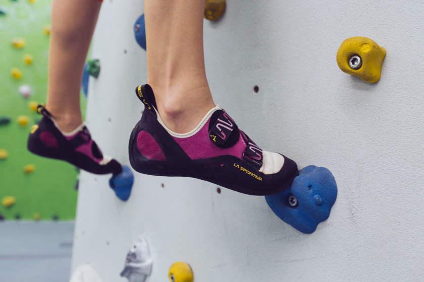 Nahaufnahme der Boulderschuhe einer Bouldererin an der Kletterwand