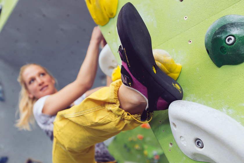 Eine Bouldererin bouldert an der Kletterwand