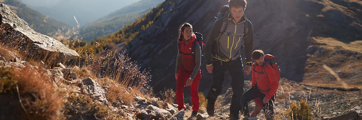 Drei Wanderer erklimmen einen Berg in alpiner Natur