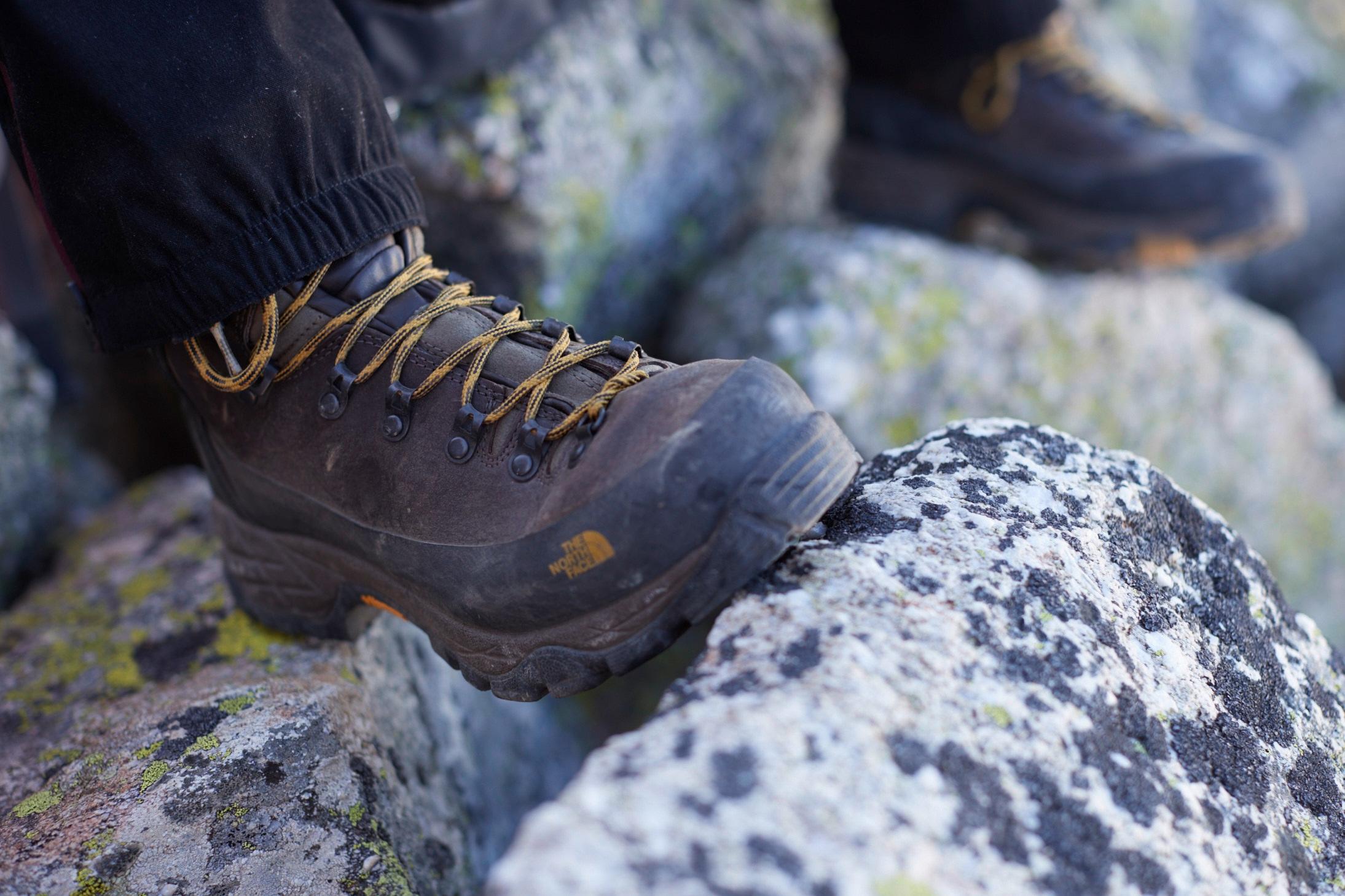 Nahaufnahme des Wanderschuhs einer Person auf einem Felsen