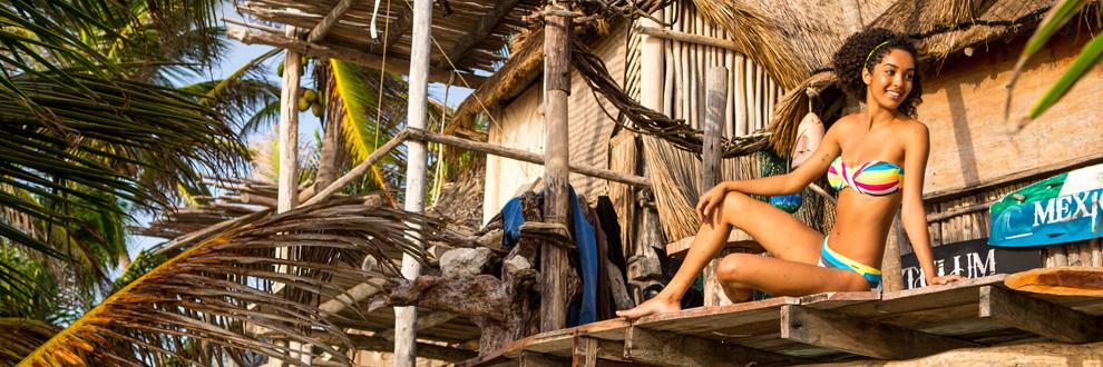 Eine Frau in einem Bikini auf einer Holzveranda.